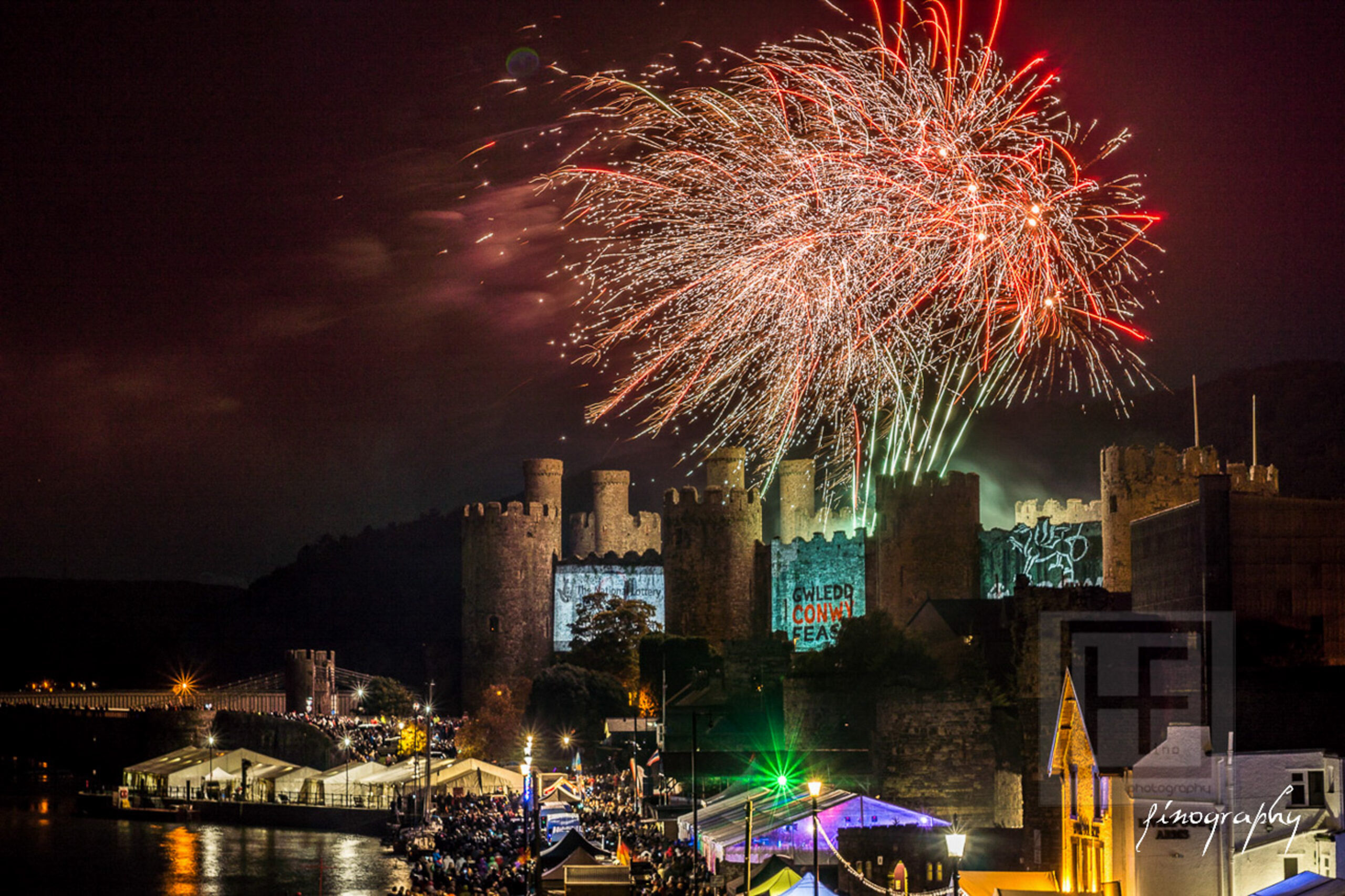 events in and around conwy - conwy castle with projection on the side and fireworks