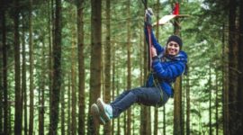 woman in a forest on a zip line